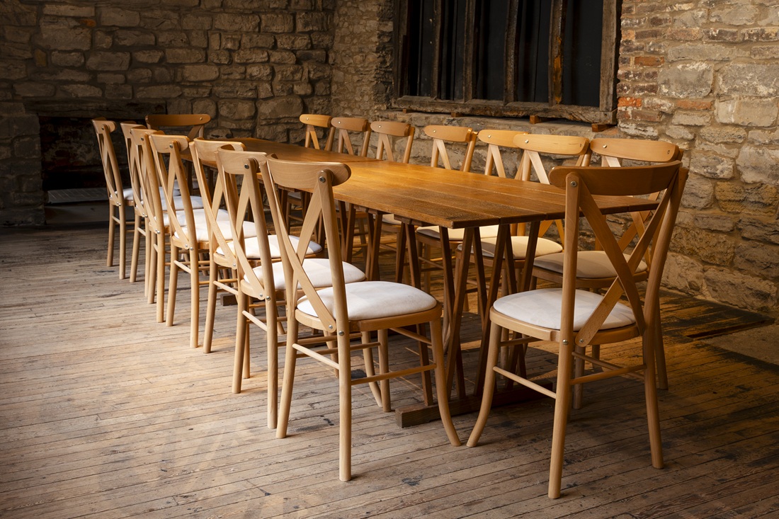 a tables with chairs around it in a room with bare stone walls